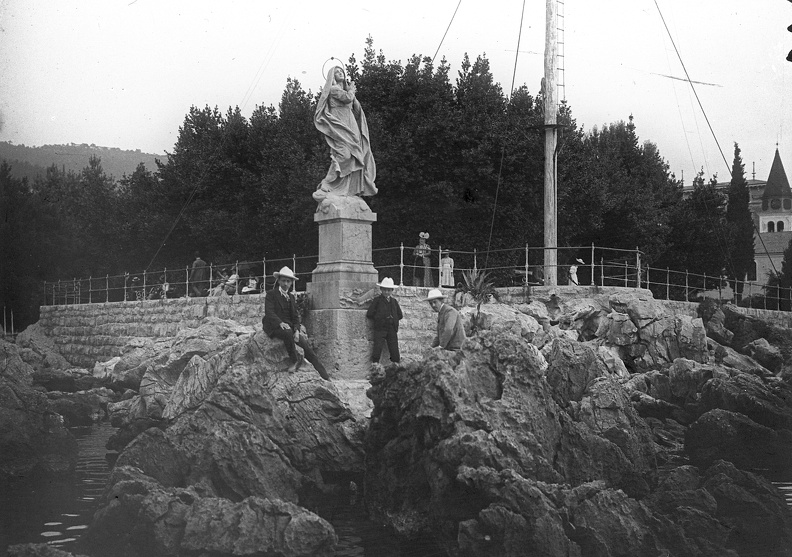 Madonna szobor a tengerparti sétánynál, jobbra a Szent Jakab templom.