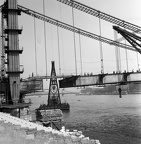 az Erzsébet híd építése, úszódaruk az utolsó pályaegység beemelésekor a budai hídfőnél.