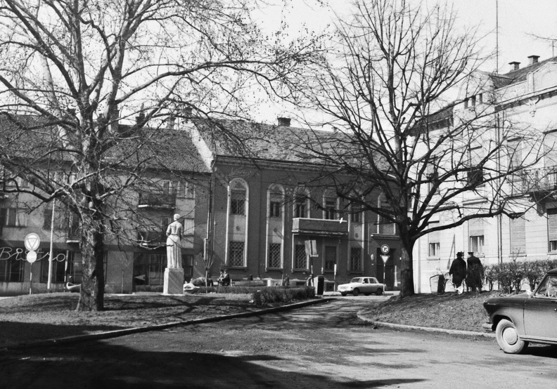 Rákóczi tér a színház mellől nézve, jobbra a Dózsa György utca torkolata. Marton László Nő hárfával (1963).